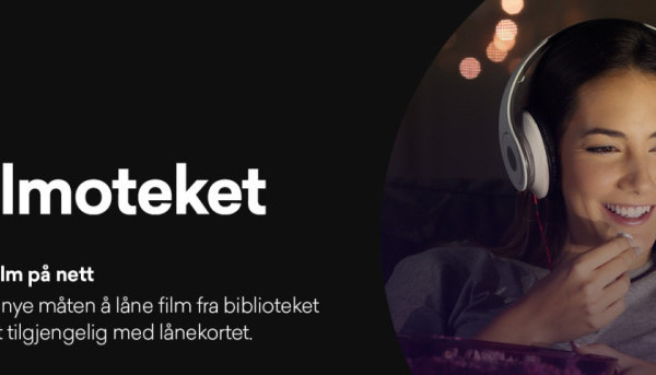 Bildet viser dame som ser film på skjerm med "headset" i et mørkt rom